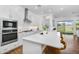 Well-lit kitchen featuring white cabinetry, stainless steel appliances, and a center island with seating at 8140 E June St, Mesa, AZ 85207
