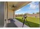 Inviting covered patio area with outdoor seating, a telescope, and views of the well-maintained artificial grass backyard at 8140 E June St, Mesa, AZ 85207