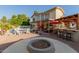 Inviting backyard with a fire pit, outdoor kitchen, patio, and lush landscaping surrounding the sparkling pool at 826 W Royal Palms Dr, Gilbert, AZ 85233