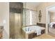 Elegant bathroom with a walk-in shower and soaking tub, complemented by natural stone accents and soft lighting at 826 W Royal Palms Dr, Gilbert, AZ 85233