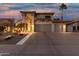 Charming two-story home featuring a spacious three-car garage and well-maintained landscaping at dusk at 826 W Royal Palms Dr, Gilbert, AZ 85233