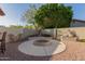 Backyard fire pit with surrounding lounge area, xeriscaping, and privacy wall at 826 W Royal Palms Dr, Gilbert, AZ 85233