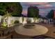 Backyard fire pit with circular stone patio, seating, and lush landscaping at 826 W Royal Palms Dr, Gilbert, AZ 85233