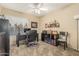 Cozy home office features a ceiling fan, a black desk and chair and a dark colored bookcase at 826 W Royal Palms Dr, Gilbert, AZ 85233