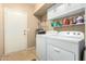 Laundry room with washer, dryer, storage shelves, and access door at 826 W Royal Palms Dr, Gilbert, AZ 85233