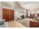 Inviting living room featuring high ceilings, large windows, a cozy sitting area, and a decorative front door at 826 W Royal Palms Dr, Gilbert, AZ 85233