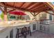 The outdoor kitchen is complete with a grill, sink, bar seating, and a shaded pergola for outdoor gatherings at 826 W Royal Palms Dr, Gilbert, AZ 85233