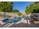 Backyard pool area with a rock waterfall feature, lush landscaping, and serene, private setting at 826 W Royal Palms Dr, Gilbert, AZ 85233