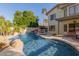 Backyard pool with a rock waterfall feature, lush landscaping, and a tranquil, resort-like ambiance at 826 W Royal Palms Dr, Gilbert, AZ 85233