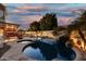 A serene pool featuring a rock waterfall, surrounding landscaping, and a view of the home's patio at 826 W Royal Palms Dr, Gilbert, AZ 85233