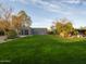 Extensive backyard with lush lawn, desert landscaping, mature trees, and a contemporary home design at 8433 E Cholla St, Scottsdale, AZ 85260