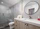 Modern bathroom with a walk-in shower, sleek vanity, round mirror, and contemporary lighting at 8433 E Cholla St, Scottsdale, AZ 85260