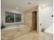 Bright bathroom featuring a travertine shower, travertine floors, and a soaking tub at 8433 E Cholla St, Scottsdale, AZ 85260