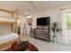 Bedroom with bunk beds, mounted TV, modern dresser, and a view of the exterior at 8433 E Cholla St, Scottsdale, AZ 85260