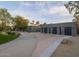 Elegant home featuring a long driveway leading to a multi-car garage and desert landscaping at 8433 E Cholla St, Scottsdale, AZ 85260
