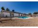 Backyard with a sparkling pool, gravel landscaping, and charming swing set at 8602 W Clarendon Ave, Phoenix, AZ 85037