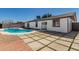 Backyard featuring a pool, a well-manicured lawn, and a unique tiled patio at 8602 W Clarendon Ave, Phoenix, AZ 85037