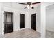Spacious bedroom featuring a ceiling fan, light gray floors, and multiple doors at 8602 W Clarendon Ave, Phoenix, AZ 85037