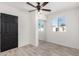 Bright bedroom with a ceiling fan, wood-look tile floors, and mirrored closet doors at 8602 W Clarendon Ave, Phoenix, AZ 85037