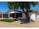Charming single-story home featuring a well-manicured front yard and a striking red front door at 8602 W Clarendon Ave, Phoenix, AZ 85037