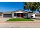Charming single-story home featuring a well-manicured front yard and a striking red front door at 8602 W Clarendon Ave, Phoenix, AZ 85037