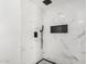 Walk in shower with white marble tile, sleek black fixtures, and hexagon tile floor at 8602 W Clarendon Ave, Phoenix, AZ 85037