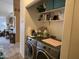 A laundry room with a washer, dryer, and storage shelves at 8900 E Rainier Dr, Gold Canyon, AZ 85118