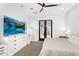 Bright bedroom with a ceiling fan, TV and french doors to an outdoor balcony or patio at 9960 E Revolution Dr, Mesa, AZ 85212