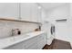 Clean and modern laundry room with new washer and dryer and plenty of cabinet space at 9960 E Revolution Dr, Mesa, AZ 85212