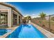 An exterior view of the backyard featuring a refreshing pool, outdoor kitchen, and dining area at 11203 N Northfield St, Surprise, AZ 85388