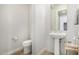 Bathroom features a pedestal sink and decorative mirror at 11203 N Northfield St, Surprise, AZ 85388