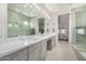 Bright bathroom with double sinks, stylish vanity with marble countertop and oversized seamless glass shower at 11203 N Northfield St, Surprise, AZ 85388