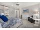 Comfortable bedroom featuring a ceiling fan, tv, sitting area, and barn door to the bathroom at 11203 N Northfield St, Surprise, AZ 85388