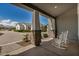 Inviting front porch with white rocking chairs, stone accents and a brick walkway at 11203 N Northfield St, Surprise, AZ 85388