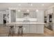 Kitchen features a large island, bar stool seating, stainless steel appliances, and hardwood floors at 11203 N Northfield St, Surprise, AZ 85388