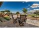 Outdoor living area with stone paver patio, custom built-in outdoor kitchen, and views of the common area at 11203 N Northfield St, Surprise, AZ 85388