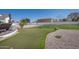 This backyard features a putting green, large grassy area, and chaise lounges by the home at 11225 E Starflower Ct, Chandler, AZ 85249
