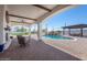 A backyard paradise featuring a covered patio, pool with waterfall, and a pergola covered dining area at 11225 E Starflower Ct, Chandler, AZ 85249