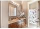 A bathroom with granite countertop, decorative mirror and a tiled shower behind a glass enclosure at 11225 E Starflower Ct, Chandler, AZ 85249