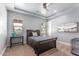 A bright bedroom with a tray ceiling, ceiling fan, two windows and comfortable furnishings at 11225 E Starflower Ct, Chandler, AZ 85249