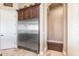 Kitchen featuring stainless steel appliances, custom cabinetry, and tile flooring with an arched hallway at 11225 E Starflower Ct, Chandler, AZ 85249