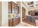 Elegant living room featuring a wet bar, custom cabinetry, granite countertops, and an arched entryway at 11225 E Starflower Ct, Chandler, AZ 85249