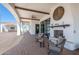 A charming covered patio with a fireplace and comfortable seating area at 11225 E Starflower Ct, Chandler, AZ 85249
