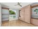 Bedroom with a Murphy bed, built-in shelving, wood floors, and a window with natural light at 13226 N Cedar Dr, Sun City, AZ 85351