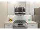 Kitchen features stainless steel appliances, stylish backsplash, and white cabinets at 13226 N Cedar Dr, Sun City, AZ 85351