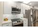 Modern kitchen features stainless steel appliances, white cabinets, and stylish backsplash at 13226 N Cedar Dr, Sun City, AZ 85351