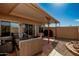Inviting covered patio area with comfortable seating, a fire pit, and a built-in grill, perfect for outdoor entertaining at 13226 N Cedar Dr, Sun City, AZ 85351