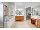 Bright bathroom features a soaking tub, vanity with wood cabinets, and a large mirror at 14302 W Laurel Ln, Surprise, AZ 85379