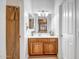 Bathroom vanity with a large mirror, cabinet storage, and nearby shower with decorative curtain at 14302 W Laurel Ln, Surprise, AZ 85379