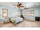 A well-lit bedroom with a large bed, two ceiling fans, and natural light from the windows at 14302 W Laurel Ln, Surprise, AZ 85379